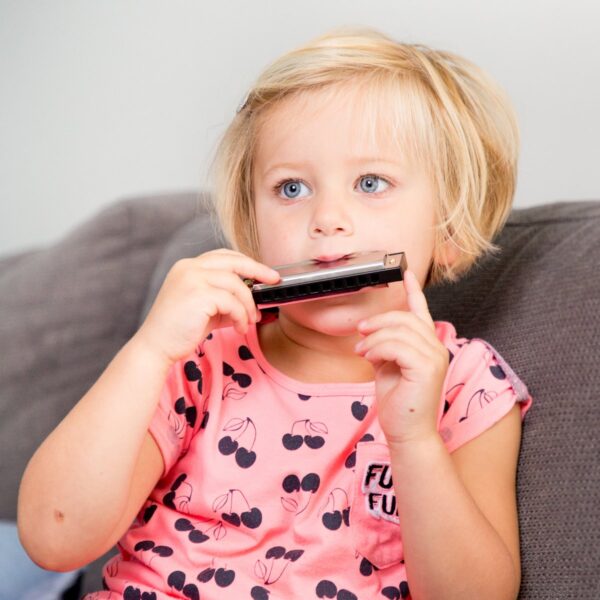 Kind speelt met New Classic Toys mondharmonica muziek speelgoed