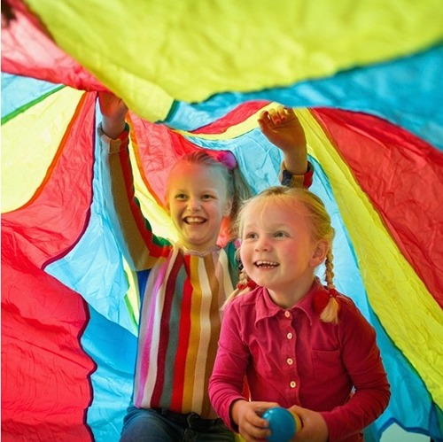 bs-toys-parachute-buitenspeelgoed-bewegen-plezier Twee kinderen onder de parachute van BS Toys