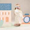 Kind speelt met Woet houten camera rollenspel speelgoed