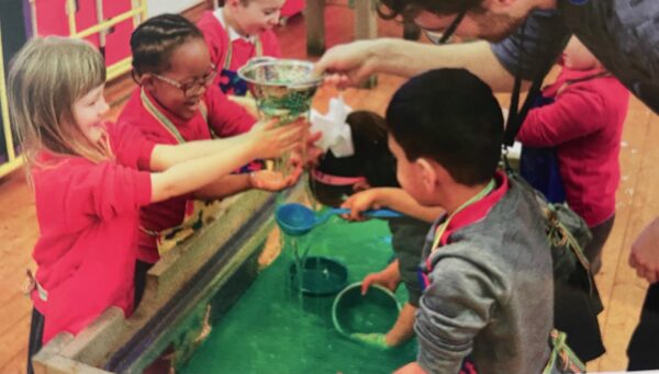 kinderen die samen spelen met attributen in een bak gel