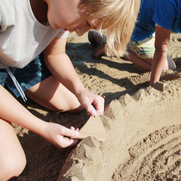 Kinderen spelen met Huckleberry sand tools in het zand
